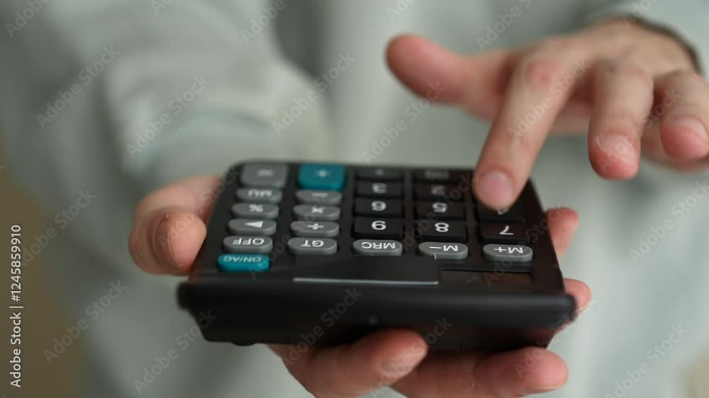 Close-up of hands holding a calculator with buttons in focus Close-up of hands holding a calculator with buttons in focus