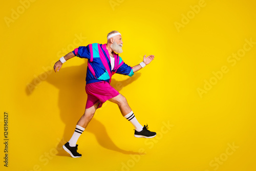 Full length photo of cheerful positive mature guy dressed retro sport jacket running emtpy space isolated yellow color background photo