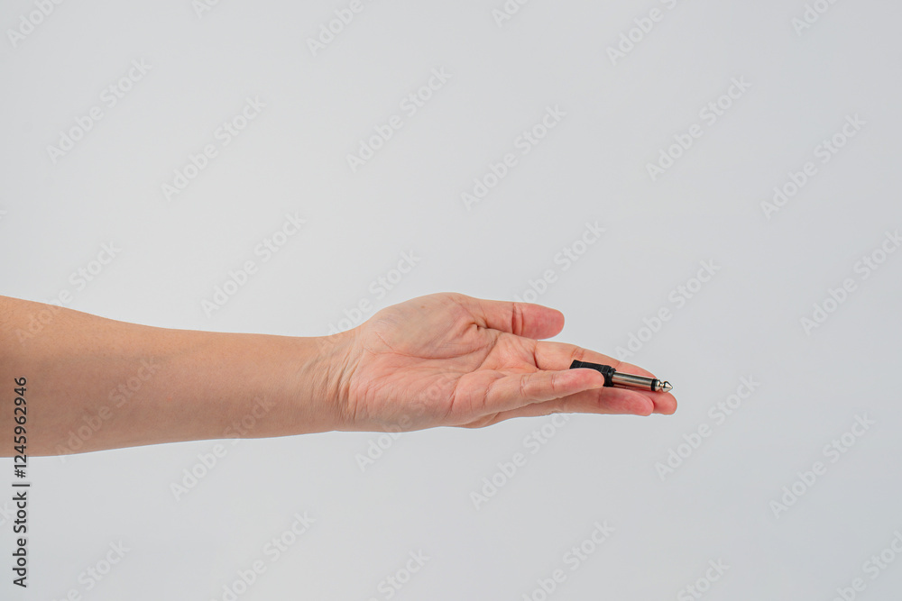 Hand and black audio cable aux isolated on white background Hand and black audio cable aux isolated on white background