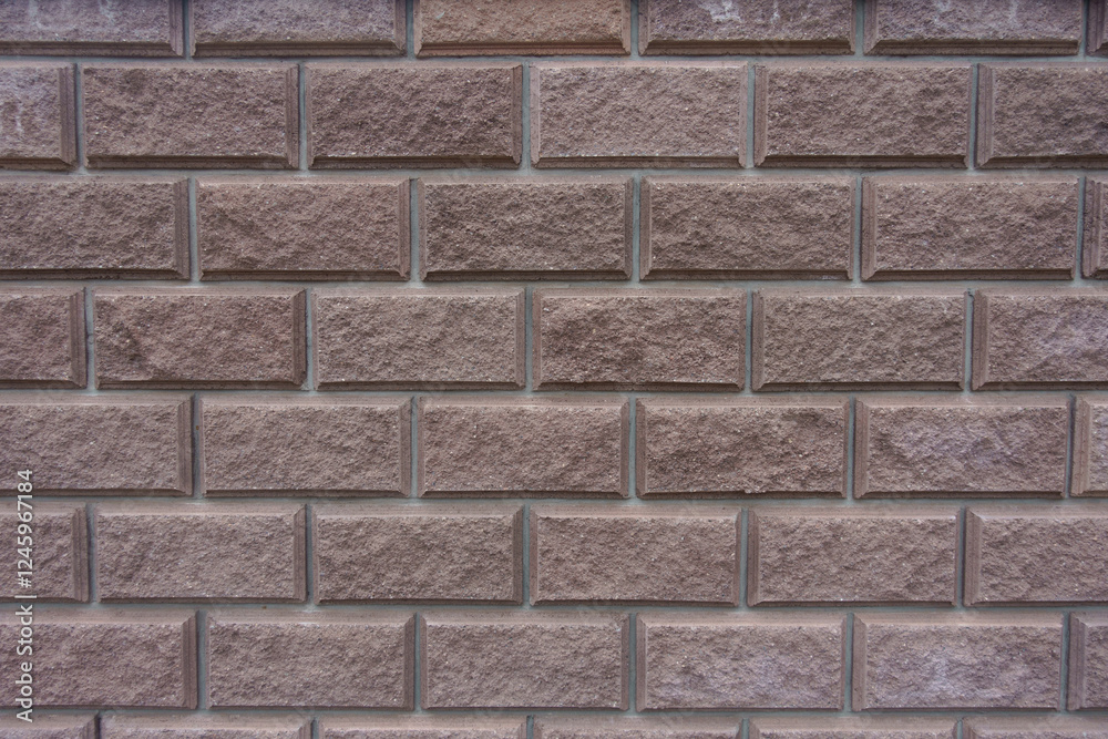 Texture of brownish pink split face brickwork with stretcher bond pattern