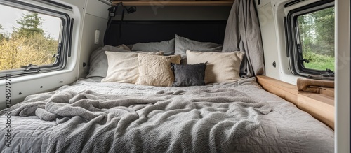 Cozy micro camper bedroom featuring a double bed with gray blankets and pillows inviting relaxation and adventure in a compact space