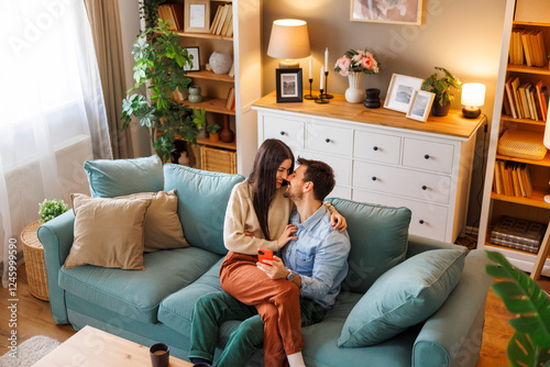 Couple in love hugging, kissing and using smart phone at home