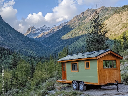 Tiny home on wheels nestled in a scenic mountain valley with snow capped peaks photo