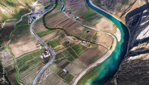 AweInspiring Top Down Aerial View of Tibetan River and Settlement Nestled in Majestic Mountains at Dusk, Capturing Stark Beauty and Serene Grandeur.