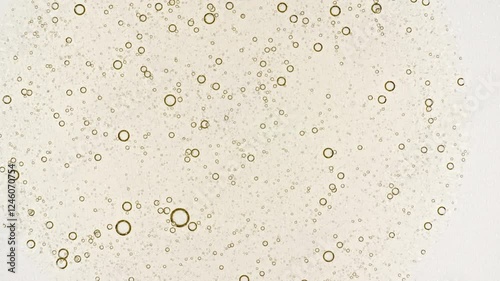 Transparent cosmetic yellow gel fluid with molecule bubbles oil spreading on a white background. Macro Shot of Natural Organic Cosmetics, Medicine. Production Close-up. Slow Motion. 4k