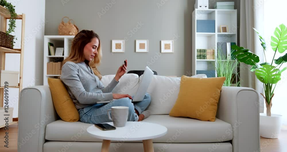 Smiling woman using laptop for online shopping at home Smiling woman using laptop for online shopping at home
