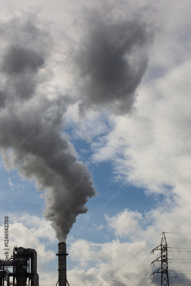 Chimney with smoke from a wood processing industry and an electric power pole. Electricity with blue sky and white clouds. Pollution Chimney with smoke from a wood processing industry and an electric power pole. Electricity with blue sky and white clouds. Pollution