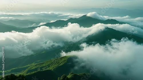Soft clouds of mist rolling over a deep green mountain landscape, blending into the sky.
