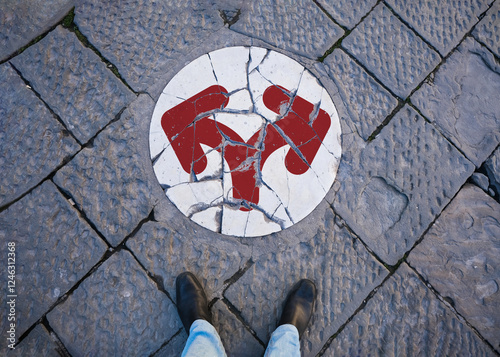A person is standing in front of a Broken White Marble Slab. It has a circular shape and there is a sign of continuing with arrows pointing to the right and left. Decision and turning or Going Concept photo