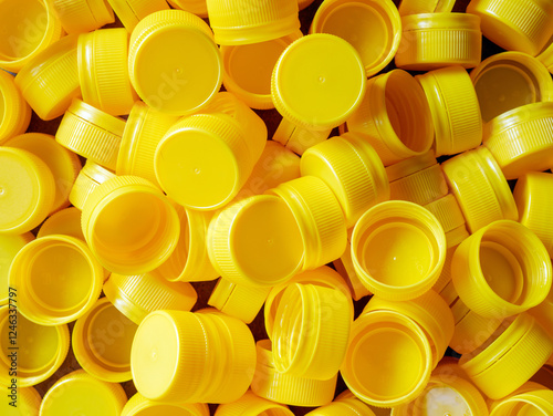 yellow plastic bottle caps.Recycling collection and production processing plastic bottle caps background ,Industrial production of bottle caps made of yellow high-density polyethylene.