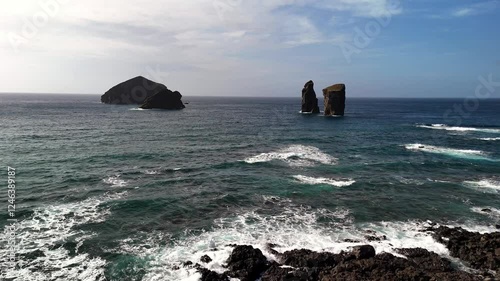 A black sand beach and cliffs, formed from solidified lava, stand as a testament to the volcanic history of São Miguel Island. The basalt rocks of Mosteiros rise dramatically from the sea, Azores