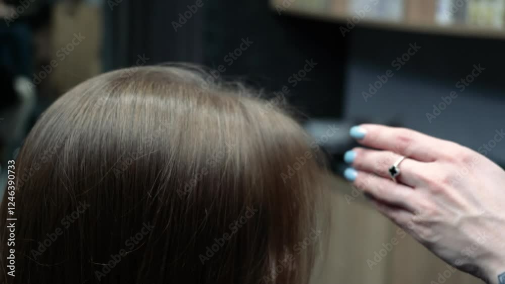 a beautiful young girl with short hair and a bob haircut is doing a procedure in a beauty salon. Hair master doing coloring and tone to client's hair close-up
