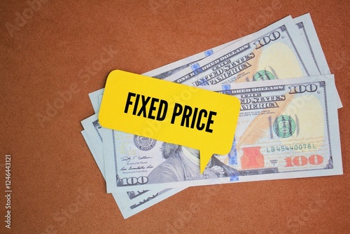 dollar bills and conversation column paper with the word fixed price. the price set for goods or services that are not subject to bargaining or barter photo