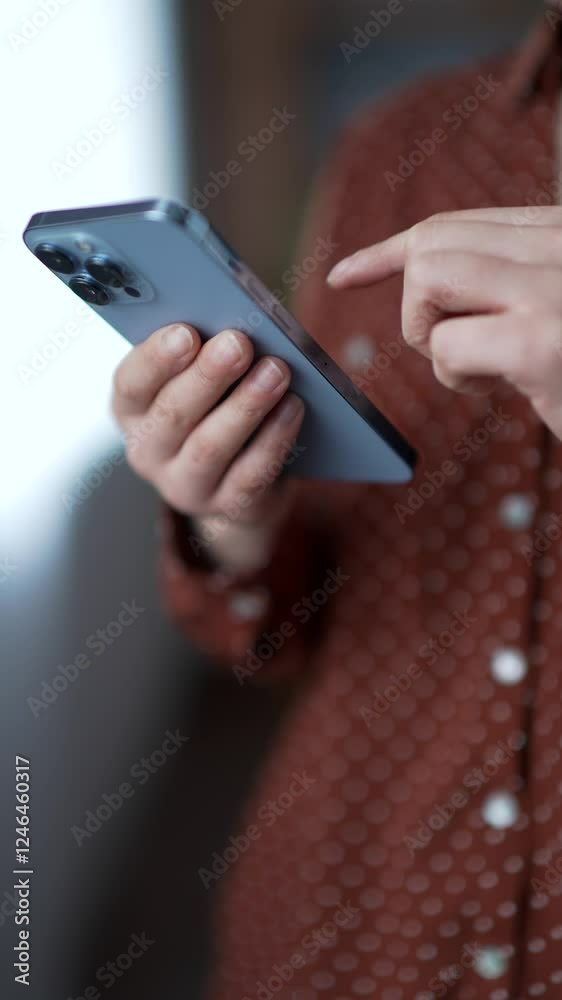 Close up of female hands using mobile phone at home. Young asian woman engaged in digital communication, browsing social media, chatting online. Concept of technology usage, connection. Vertical video