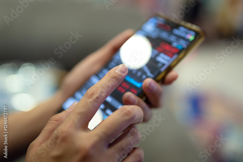 Action of a businessman is using mobilephone to review, chart analyse or trading during money or stock crisis loss situation. Financial tranding concept scene. Extreme close-up with soft focus. photo