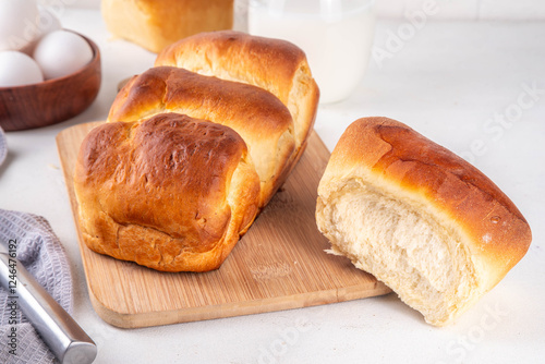 Japanese bread Shokupan, Hokkaido milk bread, or simply milk fluffy buns, on kitchen table, copy space photo