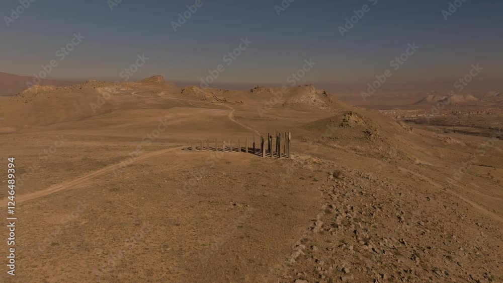 drone flyby and orbit around the presence stone column sculpture casting a long shadow on the ground, flying above the columns in the time and space land art park in cappadocia drone flyby and orbit around the presence stone column sculpture casting a long shadow on the ground, flying above the columns in the time and space land art park in cappadocia