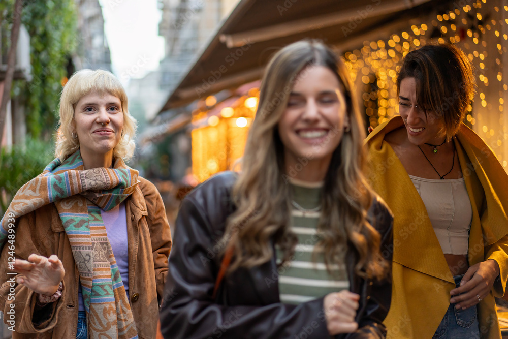 Fototapeta premium Three young women enjoying a night out together in the city lights