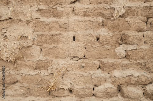 Ancient adobe wall plastered with mud closeup