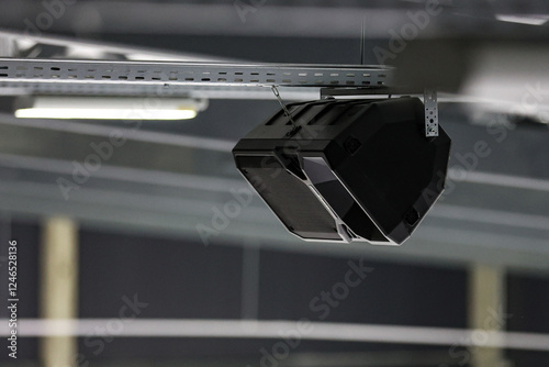 Ice hockey arena rink speaker hanging near ceiling.