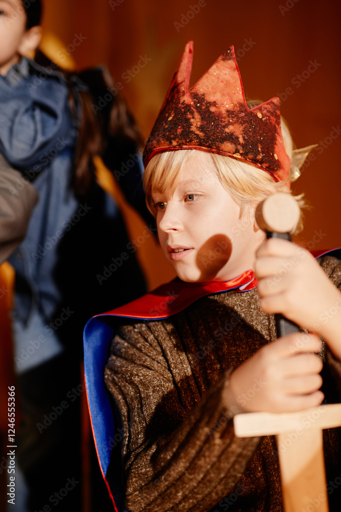 Child engaged in imaginative knight play while holding a wooden sword and wearing a crown, exhibiting focus and enjoyment in the activity Child engaged in imaginative knight play while holding a wooden sword and wearing a crown, exhibiting focus and enjoyment in the activity
