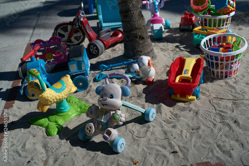 Children's toys scattered on sandy ground in sunlight on a playground., Miami, FLorida, USA photo