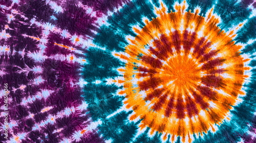 Vibrant tie-dye pattern with orange, teal, and purple colors creating a circular design.