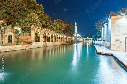 Sanliurfa, Turkey - June 19, 2023 : Balıklıgöl (Balık Lake) and Rizvaniye Mosque Landscape in beautiful sunset scenery in Şanlıurfa, Turkey.