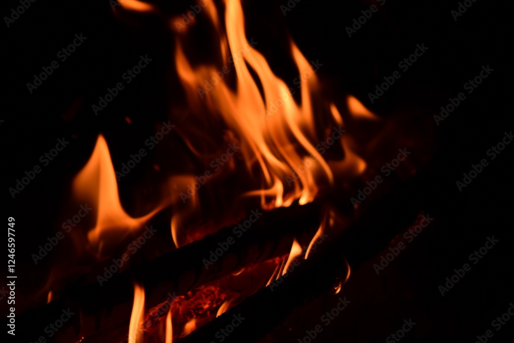 Fire flames on a black background. Burning firewood in the fireplace, close-up Fire flames on a black background. Burning firewood in the fireplace, close-up