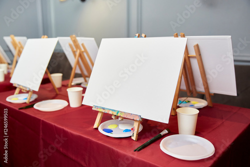 Empty canvas on a wooden easel and a brush for drawing.