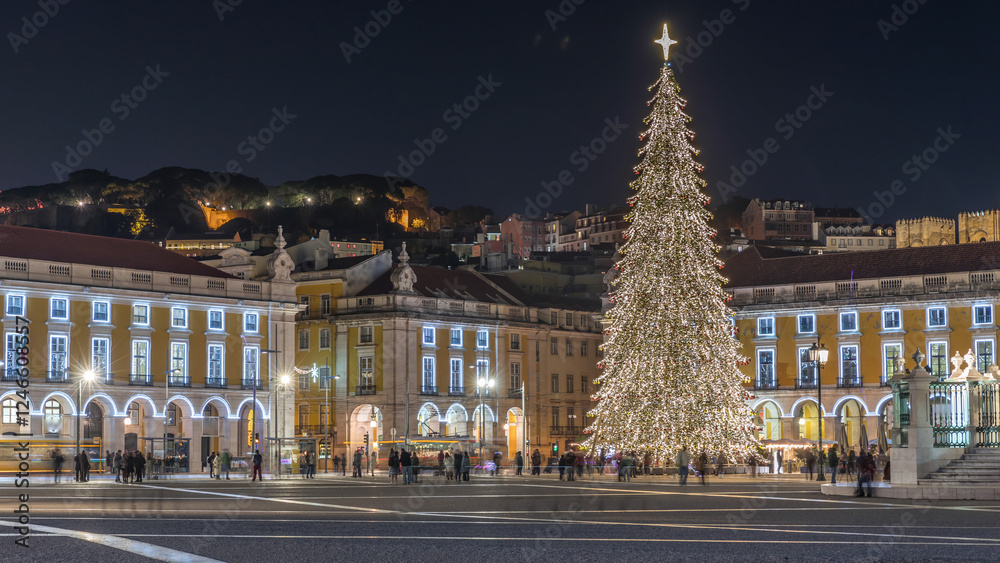 Naklejka premium Commerce Square in Lisbon illuminated at Christmas hyperlapse, with a towering tree and crowds celebrating at night. Portugal