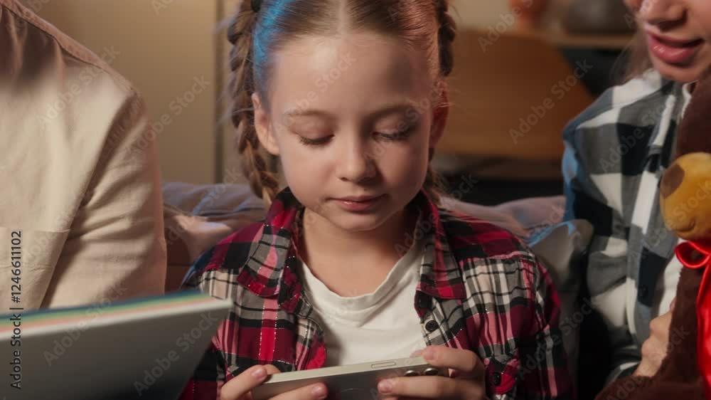 Family mother try interesting toy child daughter play video game smartphone father offer book to girl gadget addict mobile phone dependency generation modern technology overuse at home evening night