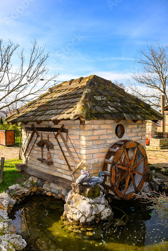 Novi Sad, Serbia- January 26, 2025: Vojvodina farm (Serbian; Vojvodjanski Salaš) a beautiful restaurant near Novi Sad. Decorated small watermill. Decorative water wheel in the garden photo