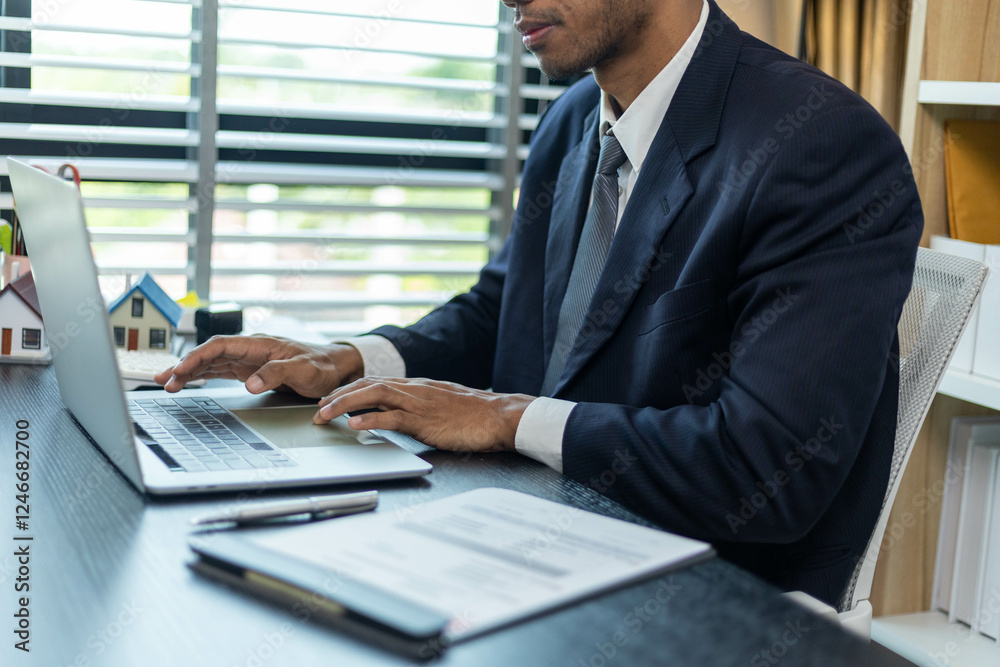 A man in a suit is typing on a laptop at a desk. Concept of professionalism and focus, as the man is dressed in a business suit and he is working on important tasks. The presence of the laptop
A man in a suit is typing on a laptop at a desk. Concept of professionalism and focus, as the man is dressed in a business suit and he is working on important tasks. The presence of the laptop