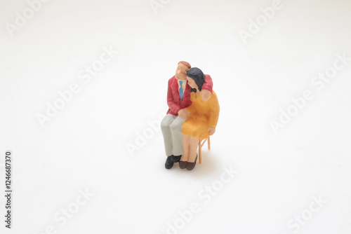 Miniature Couple Figurines Seated Together photo