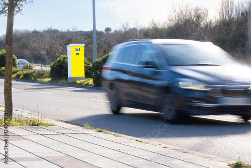 Fixed speed camera fines a car for speeding. new radars with artificial intelligence. In Pamplona, Spain. Painted in fluorescent yellow for easy visibility.