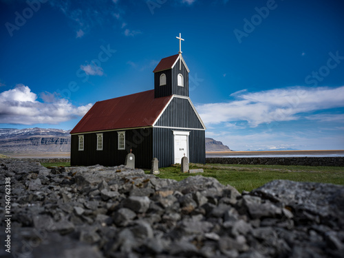 Église noire isolée en Islande, entre ciel bleu et nature sauvage photo