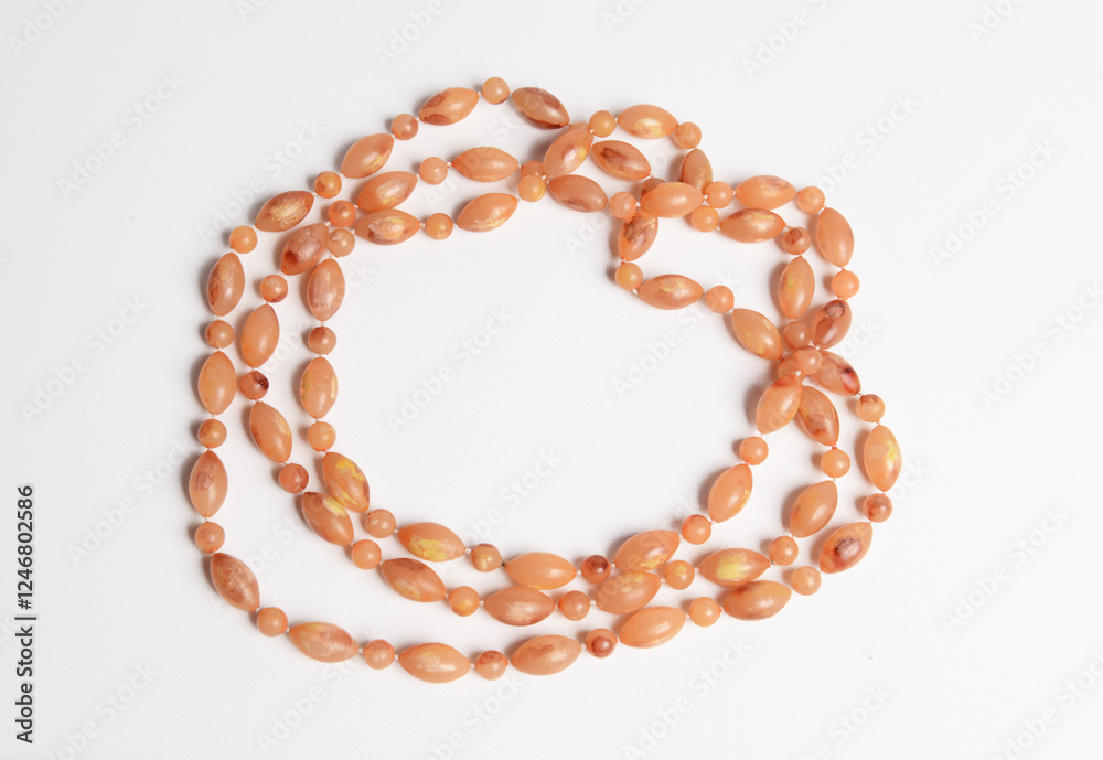 Obraz premium Oval beads loose necklace in earth tone color on white background.