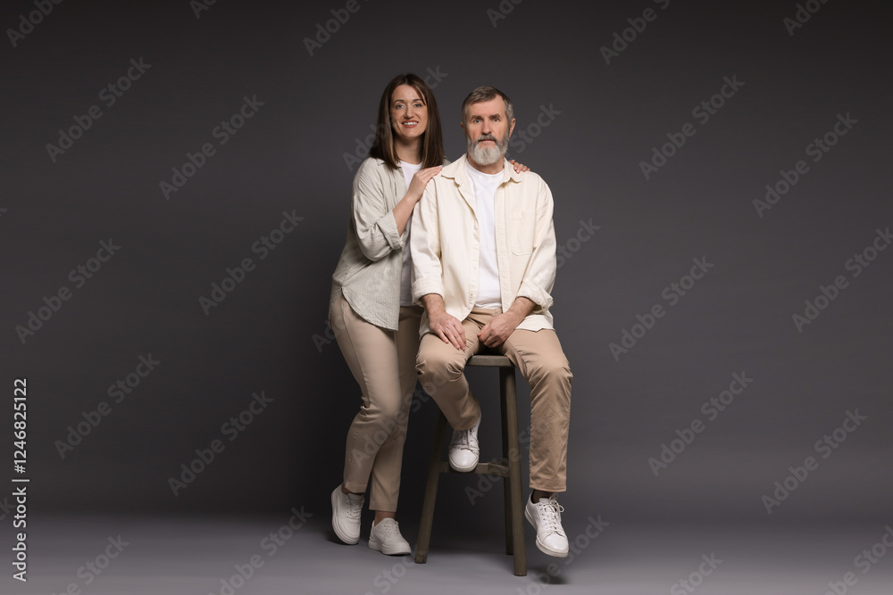Happy daughter and her father on dark background Happy daughter and her father on dark background
