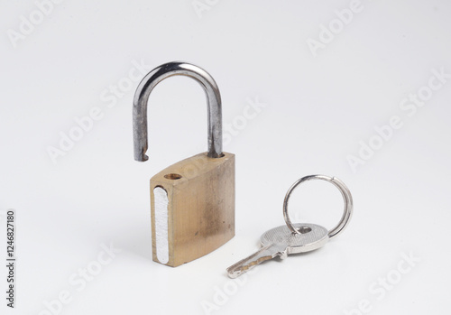 Obraz na płótnie Small old solid brass padlock in open position, with the key, isolated on white