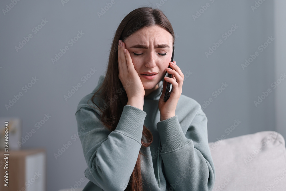 Depressed woman calling hotline for mental health help on sofa at home Depressed woman calling hotline for mental health help on sofa at home