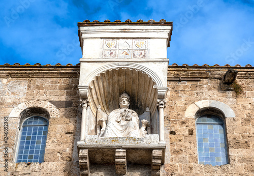 The statue of Pope Boniface VIII seated on the papal throne protrudes on the side facade of Anagni's medieval cathedral