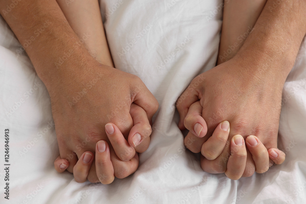Lovely couple holding hands in bed, closeup Lovely couple holding hands in bed, closeup