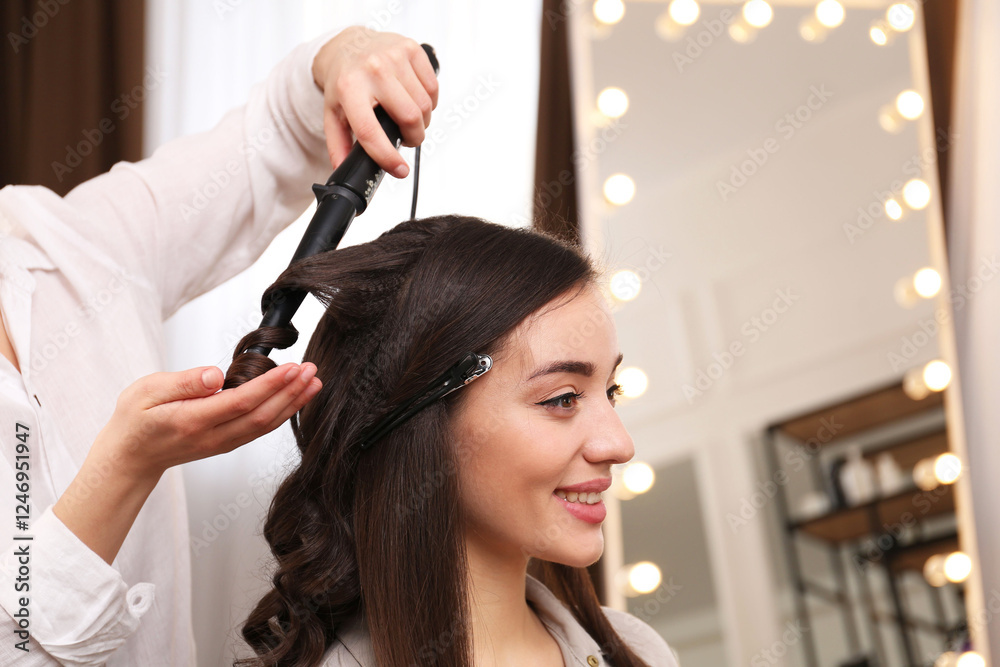 Fototapeta premium Stylist working with client in salon, making hairstyle