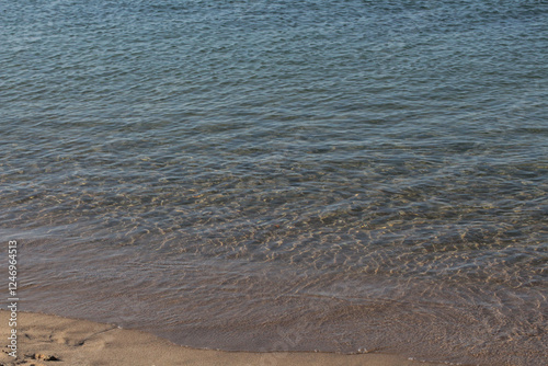 Fototapeta Naklejka Na Ścianę i Meble -  Summer vacation wavy, calm, deep blue sky, mountains, thin white clouds not visible, clear weather. boat, dinghy, rowboat far away. yellow shiny brown sea sand on shore beach. Balıkesir, Sarimsakli
