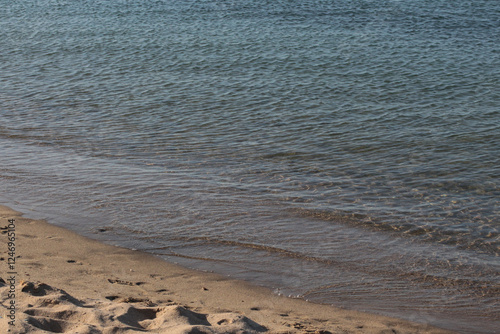 Fototapeta Naklejka Na Ścianę i Meble -  Summer vacation wavy, calm, deep blue sky, mountains, thin white clouds not visible, clear weather. boat, dinghy, rowboat far away. yellow shiny brown sea sand on shore beach. Balıkesir, Sarimsakli