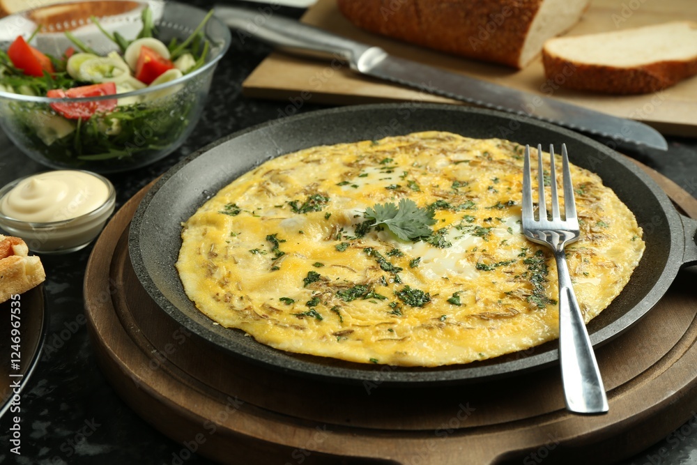 Tasty brunch. Delicious omelette and salad served on black textured table, closeup Tasty brunch. Delicious omelette and salad served on black textured table, closeup