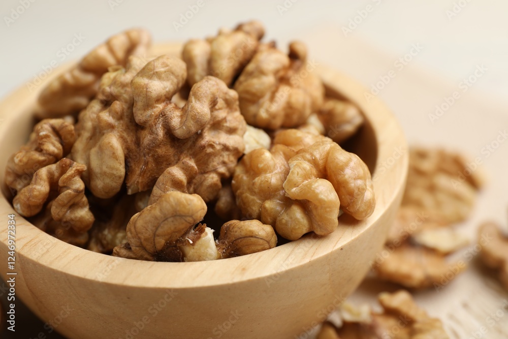 Peeled walnuts in bowl on light table, closeup Peeled walnuts in bowl on light table, closeup