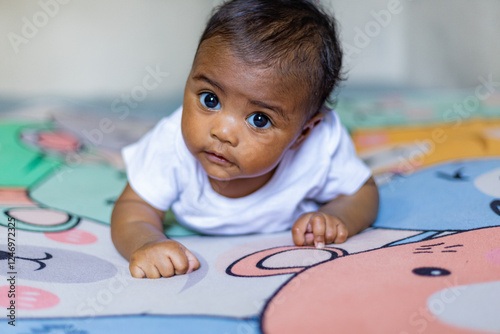 Fotografija A little girl doing tummy time, a little girl