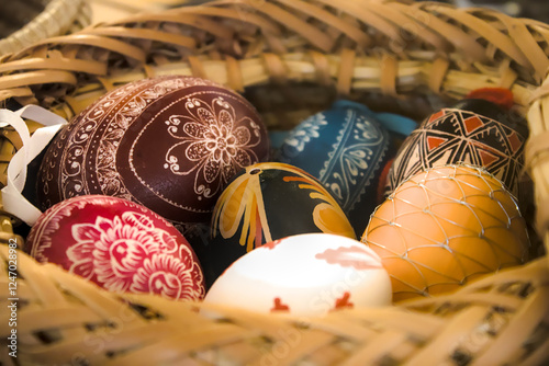 Colorful decorated Easter eggs in woven basket.